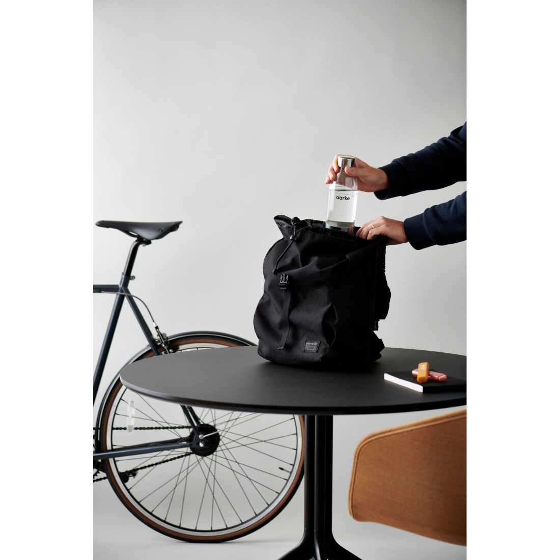 Eine Person, die eine Wasserflasche in einen Rucksack legt.