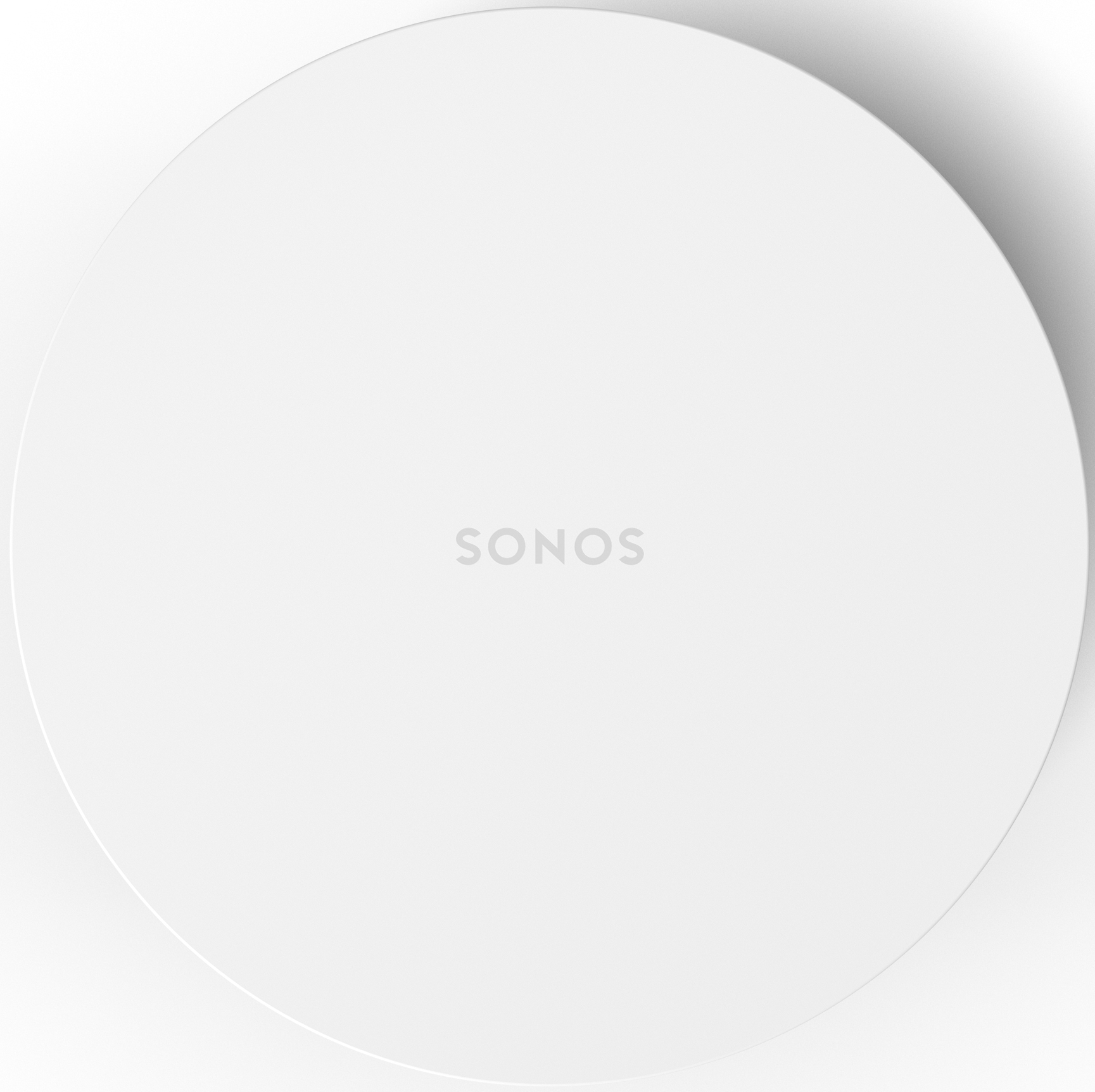A white Sonos speaker, circular with the brand name on it, placed on a white surface.