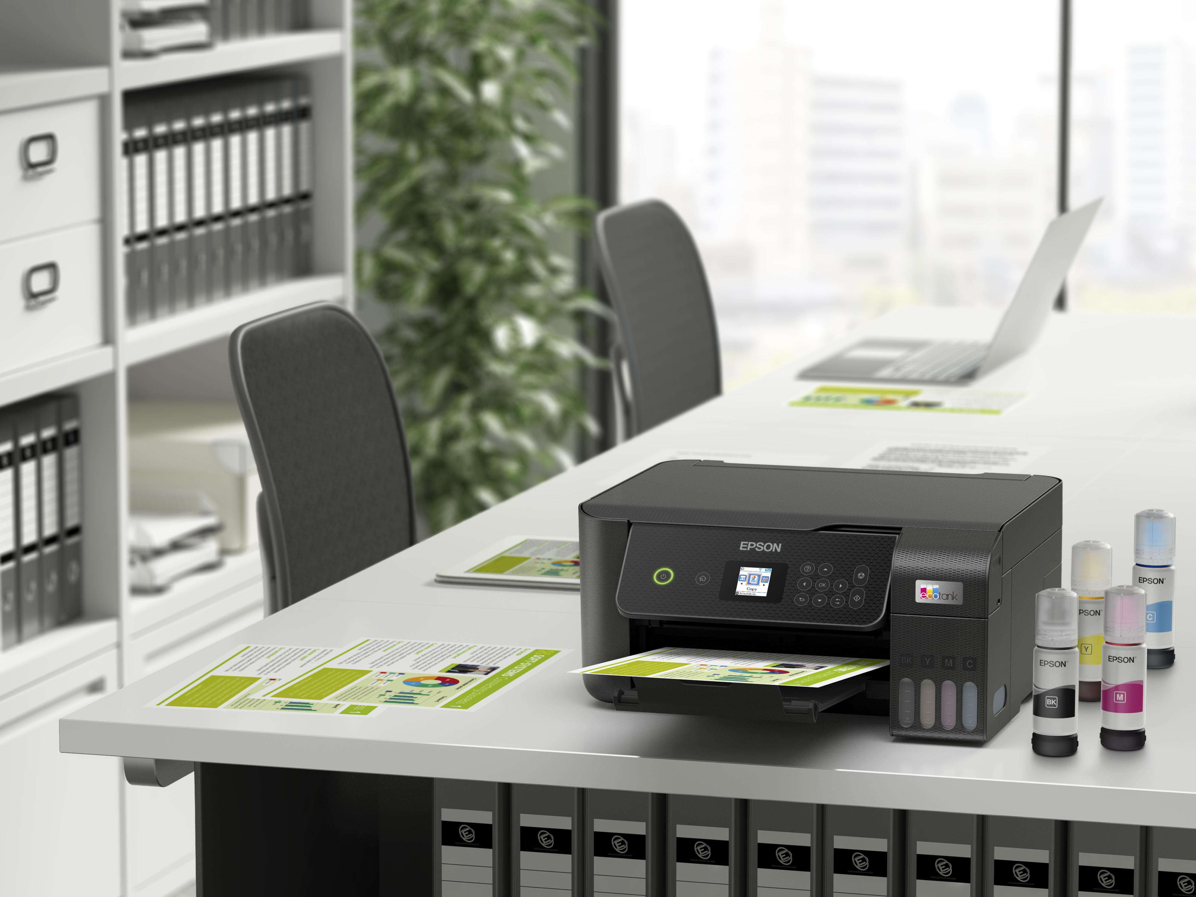 Ein Büro mit einem Drucker auf einem Tisch mit Papieren.
