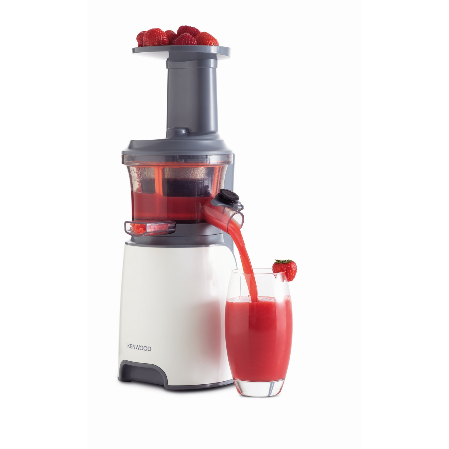 Jugo vertiéndose de una licuadora Kenwood blanca y gris en un vaso con una fresa.