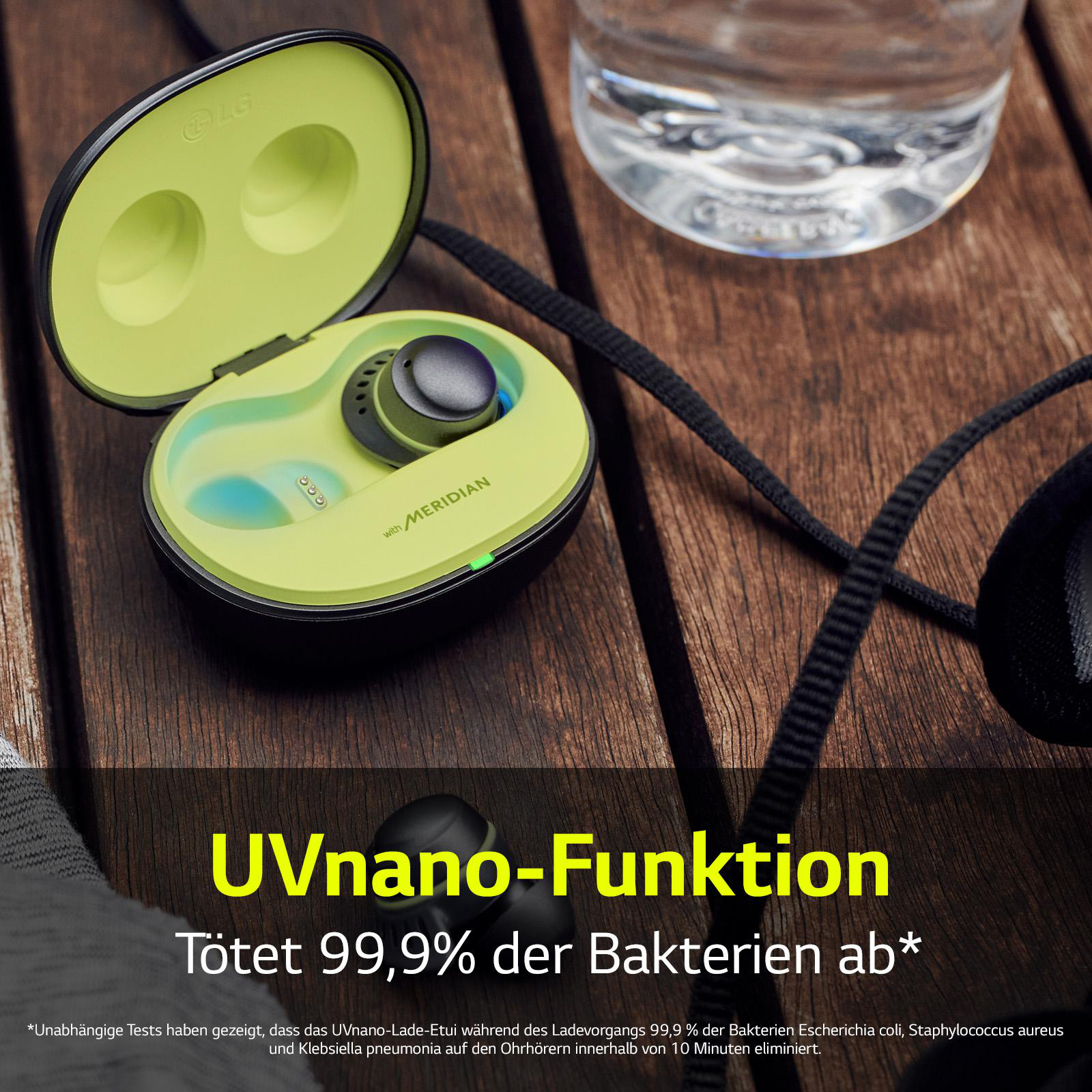 Ohrhörer in einem Ladecase, mit einer Wasserflasche und einer Holzoberfläche. Text über die UVnano-Funktion.