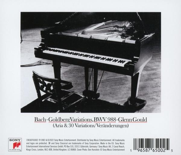 Schwarz-Weiß-Bild eines Klaviers und eines Stuhls. Das Klavier ist offen, die Tasten sind sichtbar.