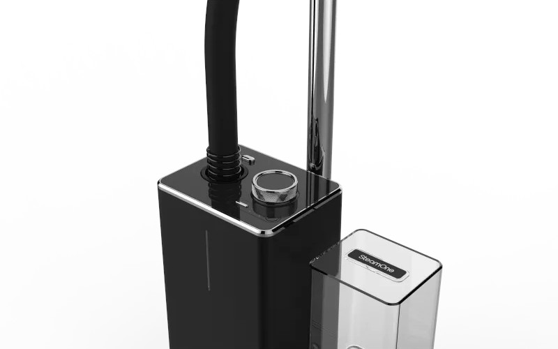 Appareil à vapeur noir et argenté. Le steamer est grand et possède un petit réservoir d'eau.