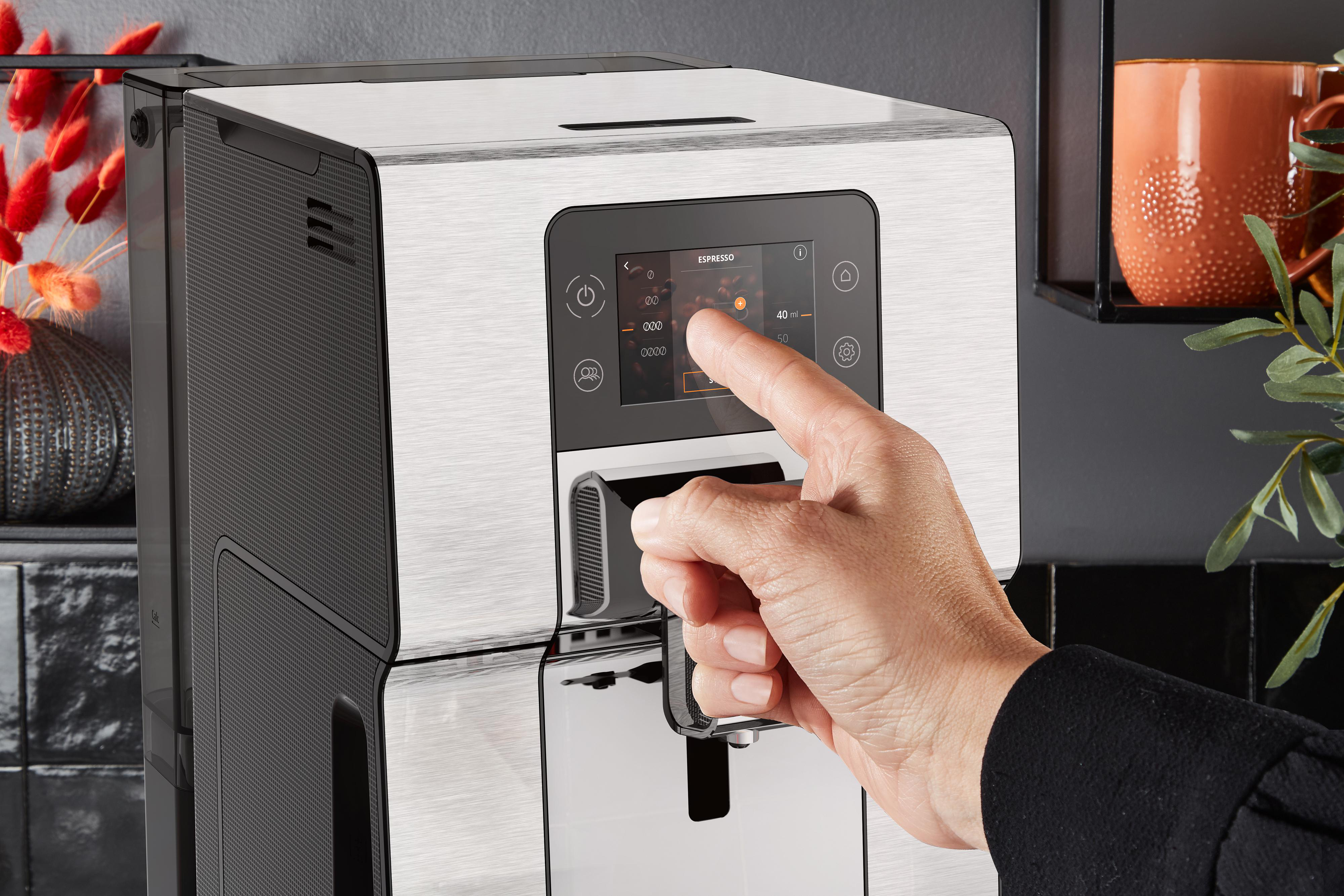Person berührt Touchscreen einer Kaffeemaschine, Espresso-Option.