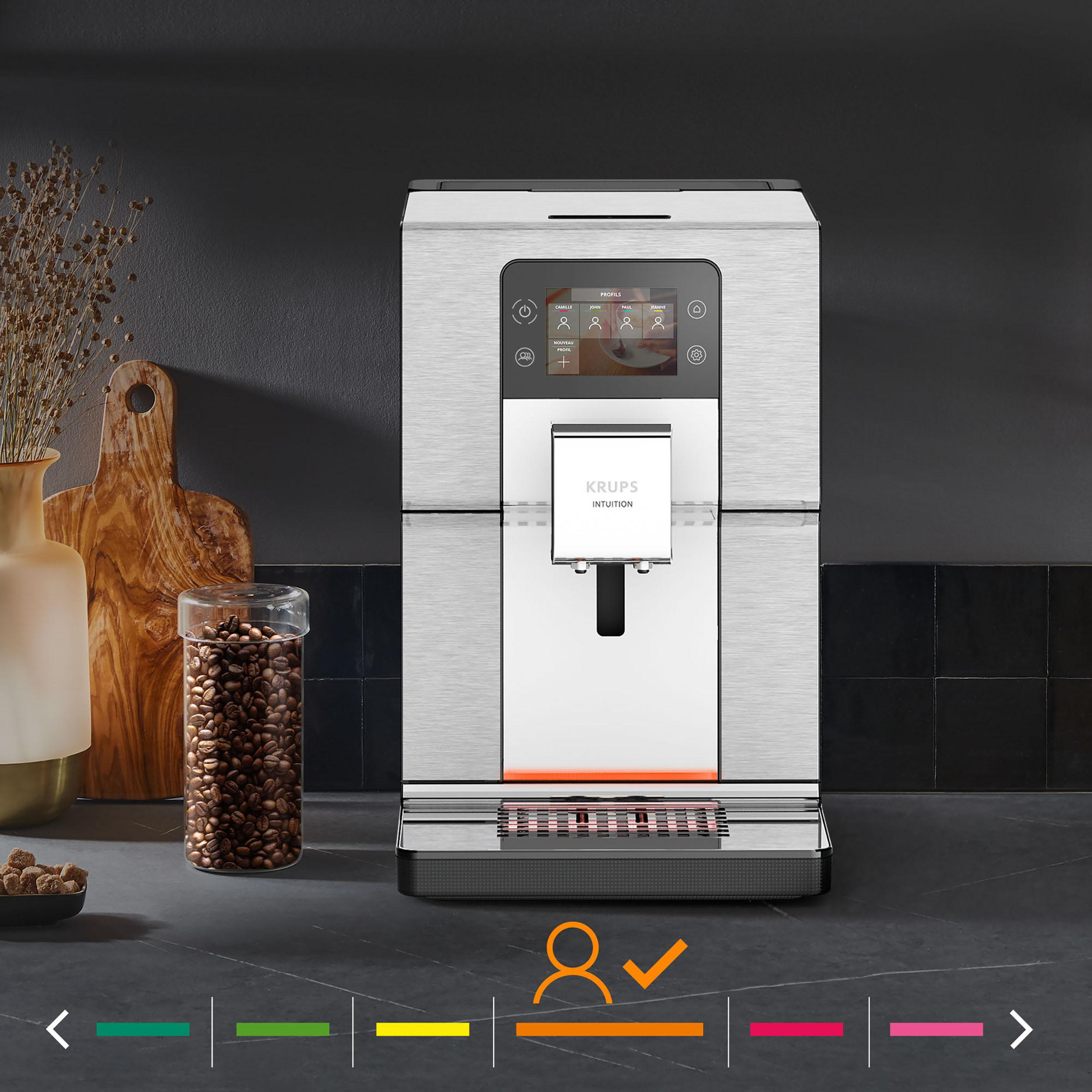 Eine silberne und schwarze Krups Intuition Kaffeemaschine mit einem Glas Kaffeebohnen.