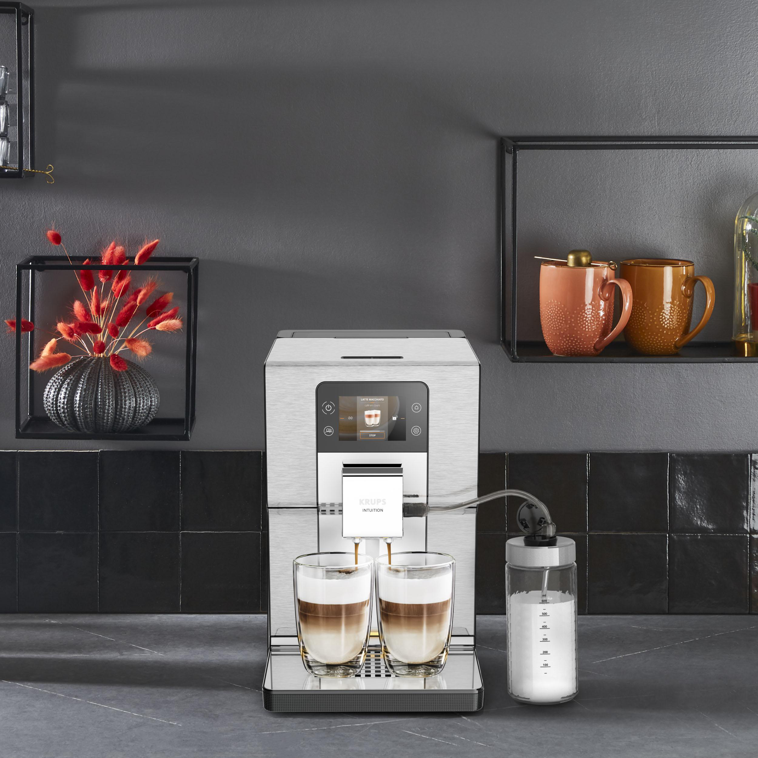 Kaffeemaschine mit zwei Gläsern geschichtetem Kaffee und einem Milchbehälter.