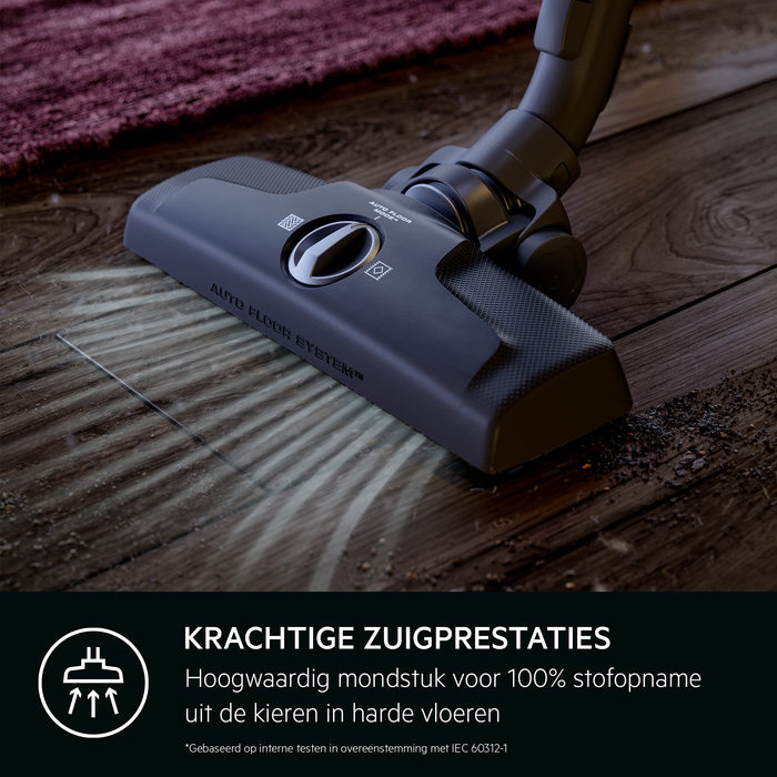 A vacuum cleaner head on a wooden floor. Text: Powerful suction performance. The background is blurry.