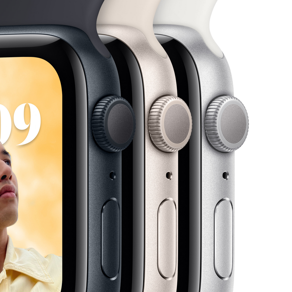 Primer plano de tres Apple Watch, diferentes colores. La pantalla de uno es visible. La cara de una persona es parcialmente visible.