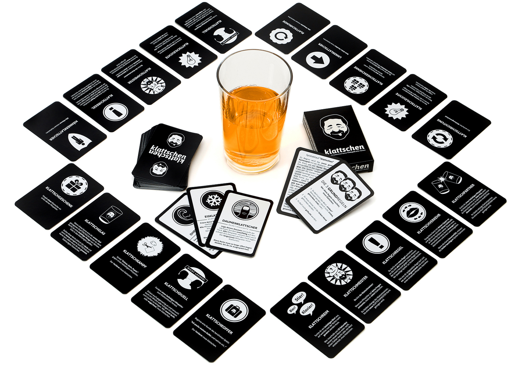 Spielaufbau mit Karten, einem Glas Getränk und Karten in Diamantenform angeordnet.