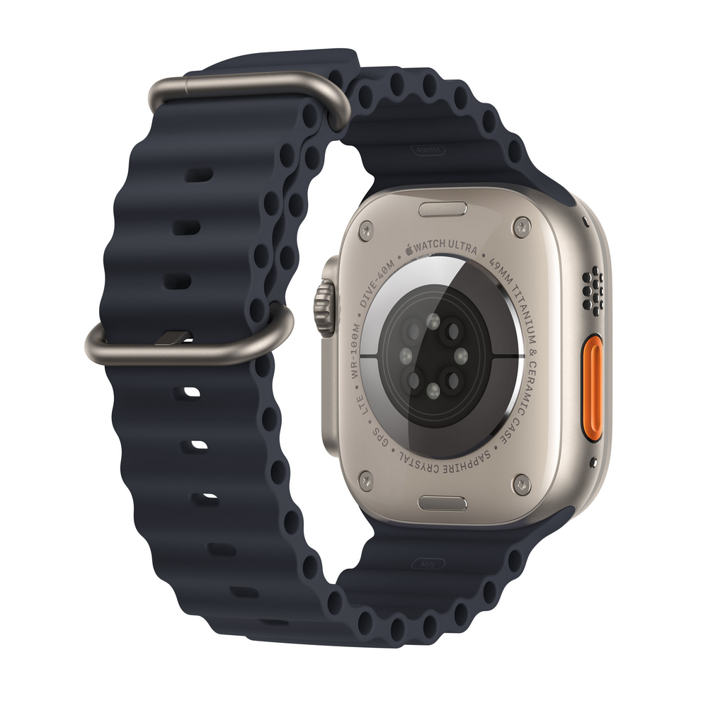 Parte trasera de un Apple Watch Ultra plateado con correa azul oscuro. Es un primer plano.