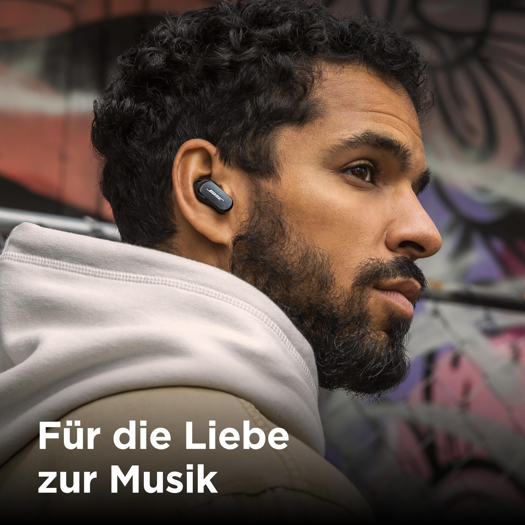 Mann mit Ohrhörern. Der Text auf dem Bild lautet: Für die Liebe zur Musik.