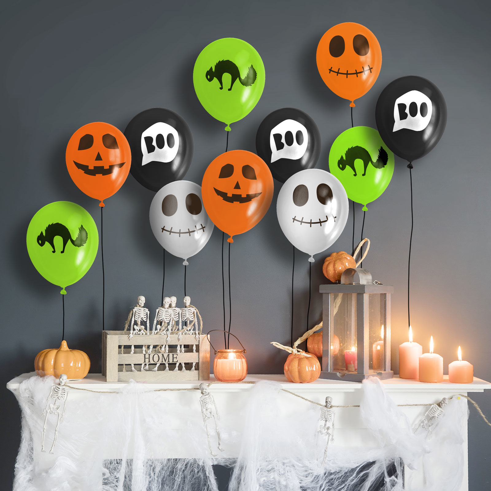 Halloween dekorációk. Lufik, csontvázak, tökök, gyertyák és egy kandallópárkány látható a képen.