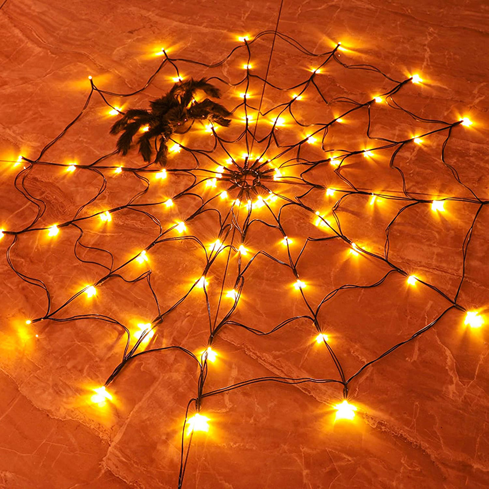 Halloween pók web világító lámpákkal, barna felületen.