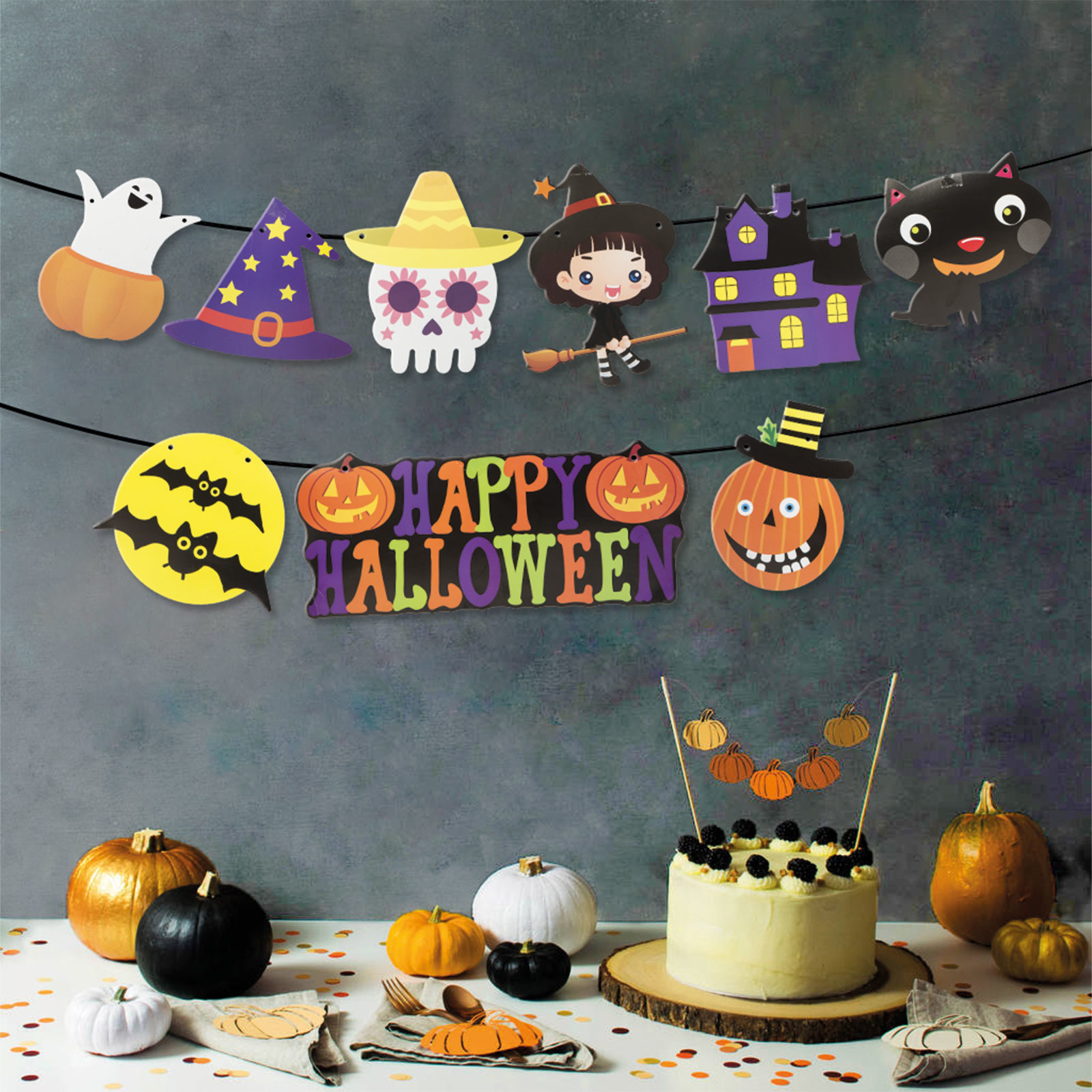 Halloween dekorációk: girland, tökök, torta és szürke fal háttér.