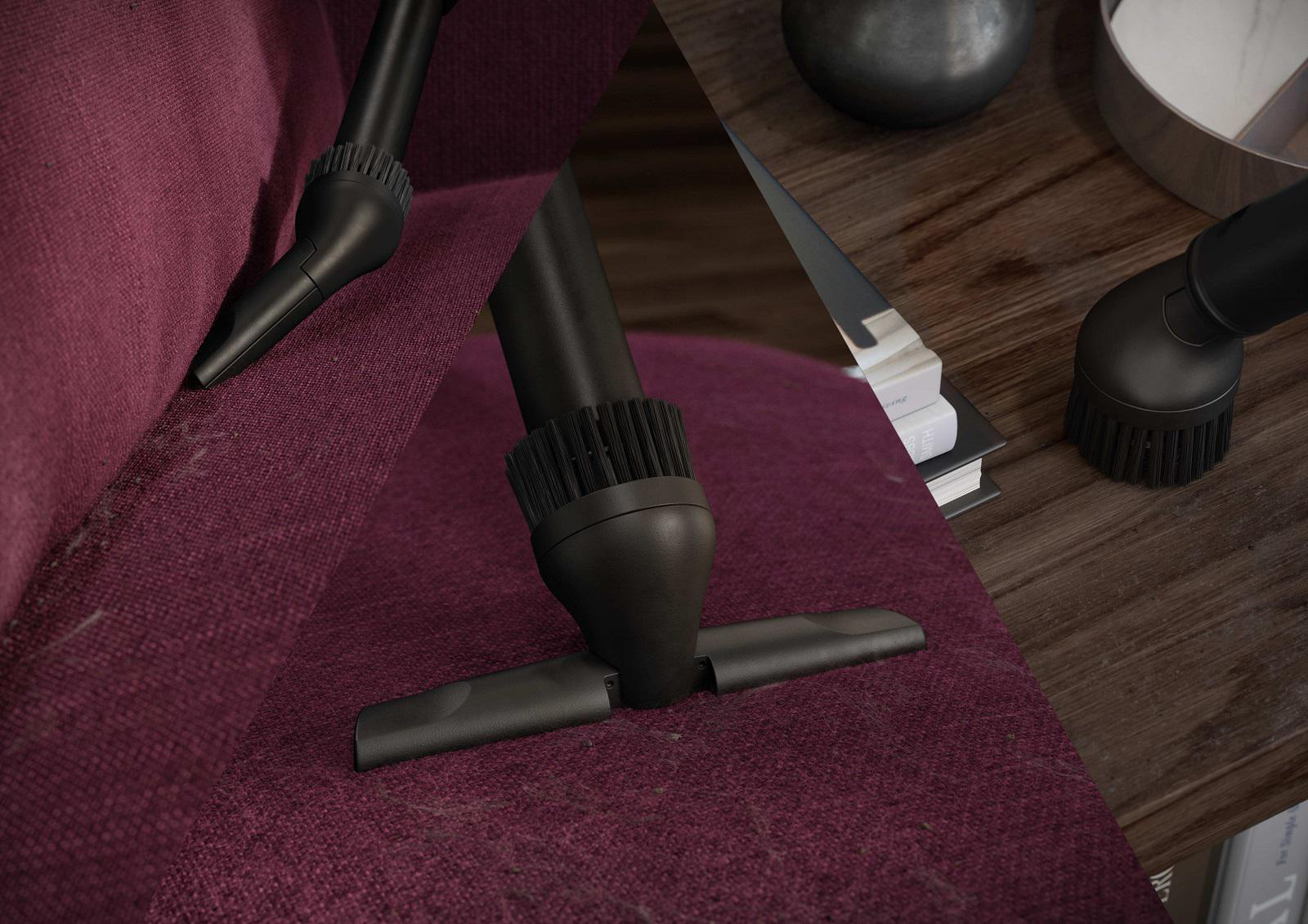 Staubsaugeraufsätze reinigen rotes Sofa und erfassen Staub und Schmutz.