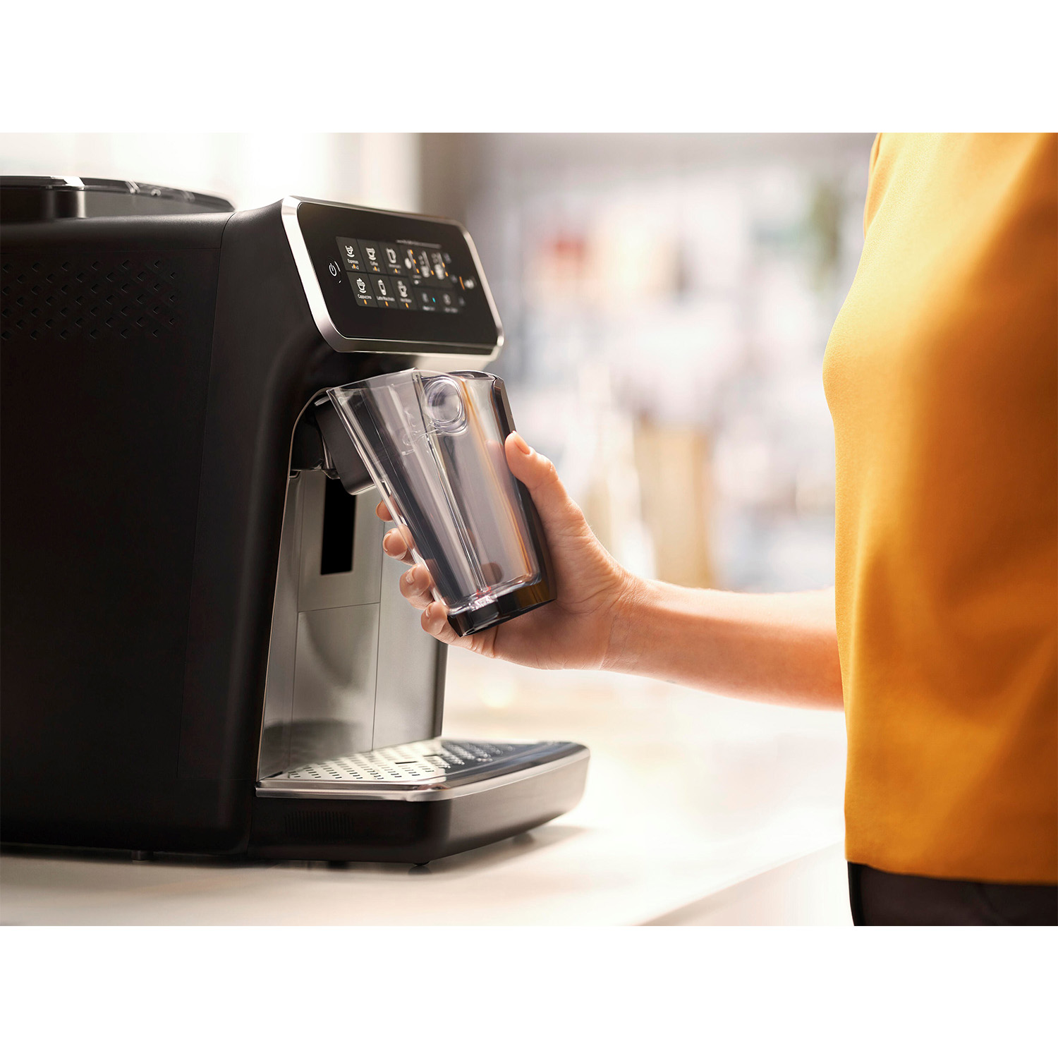 Una persona usa una macchina da caffè nera, posizionando un bicchiere.