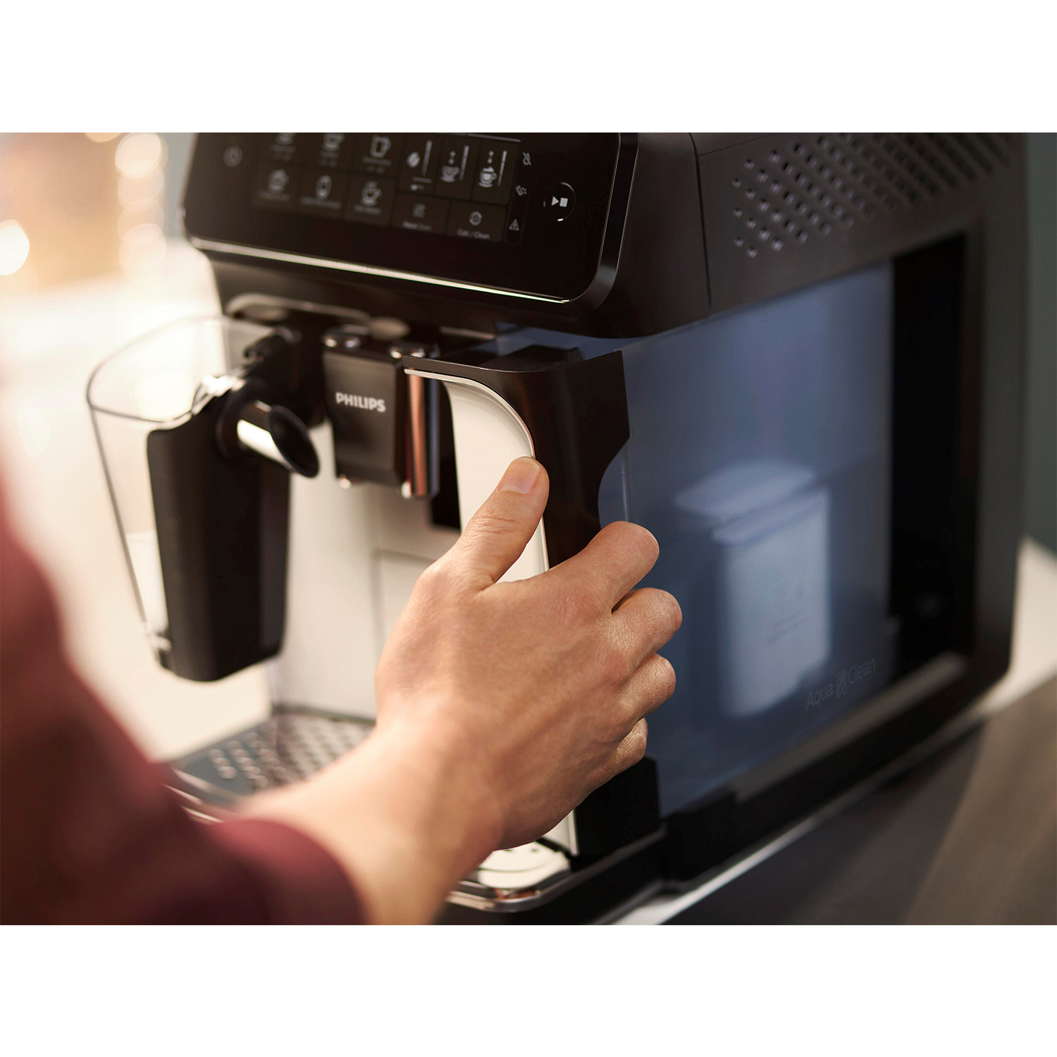 Persona che utilizza una macchina da caffè. La macchina è nera con un frontale bianco.