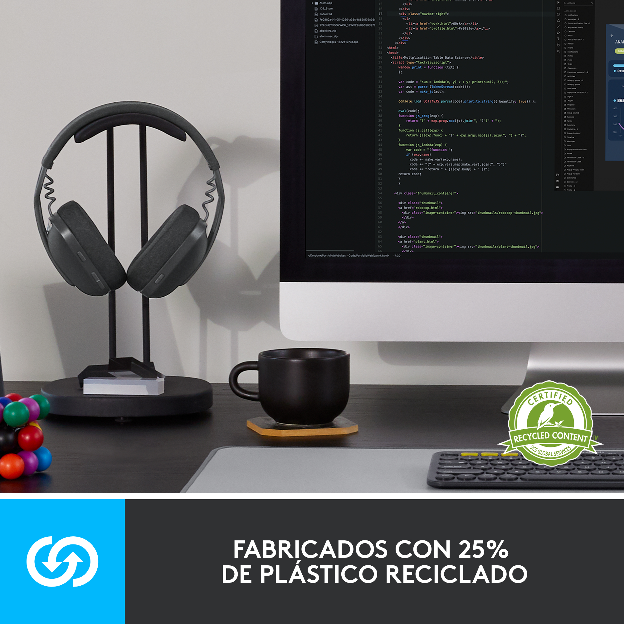 Auriculares en un soporte, una taza negra y un teclado sobre un escritorio. Un monitor muestra código.