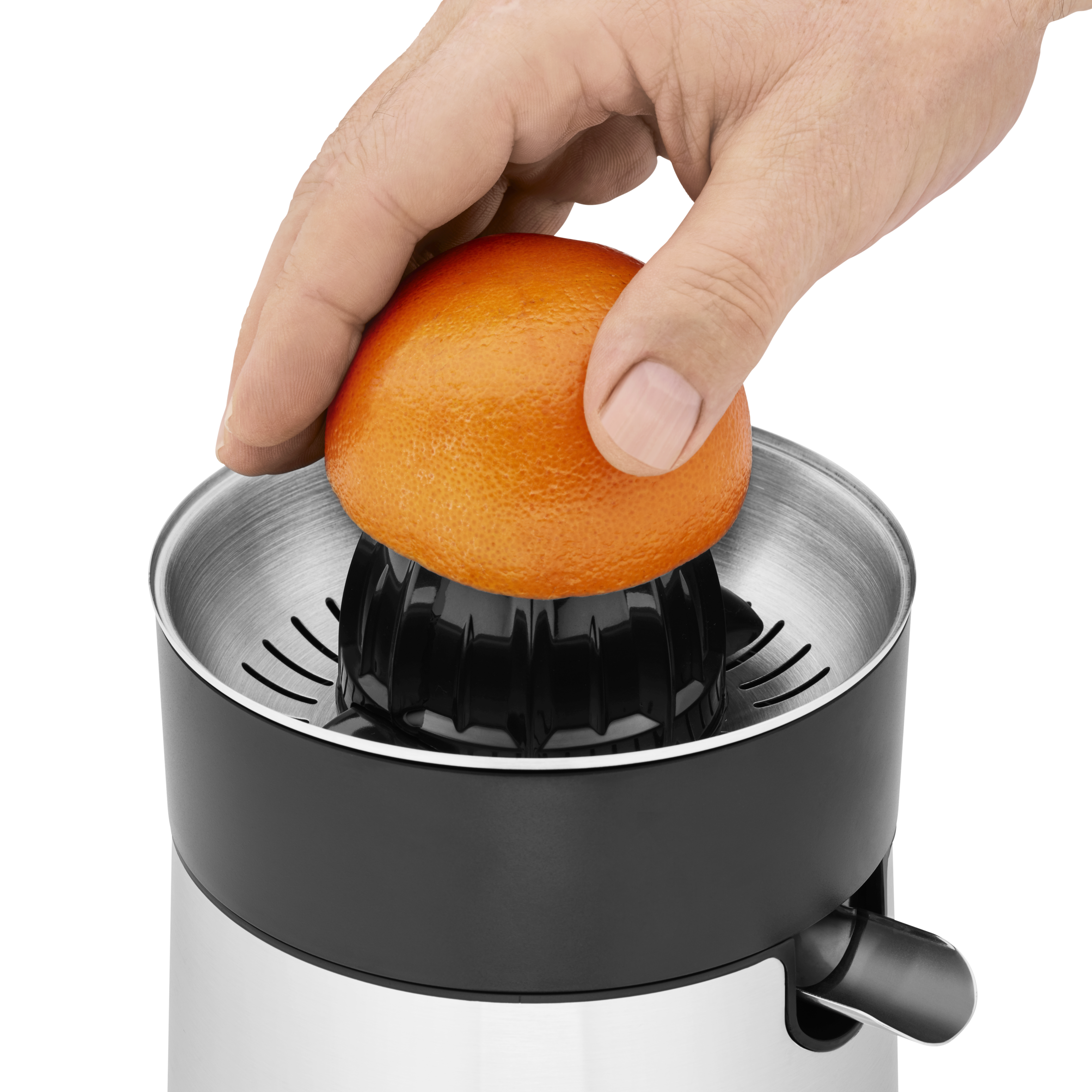 Mano exprimiendo media naranja en una exprimidora. La exprimidora tiene detalles negros y cuerpo plateado. Fondo negro.