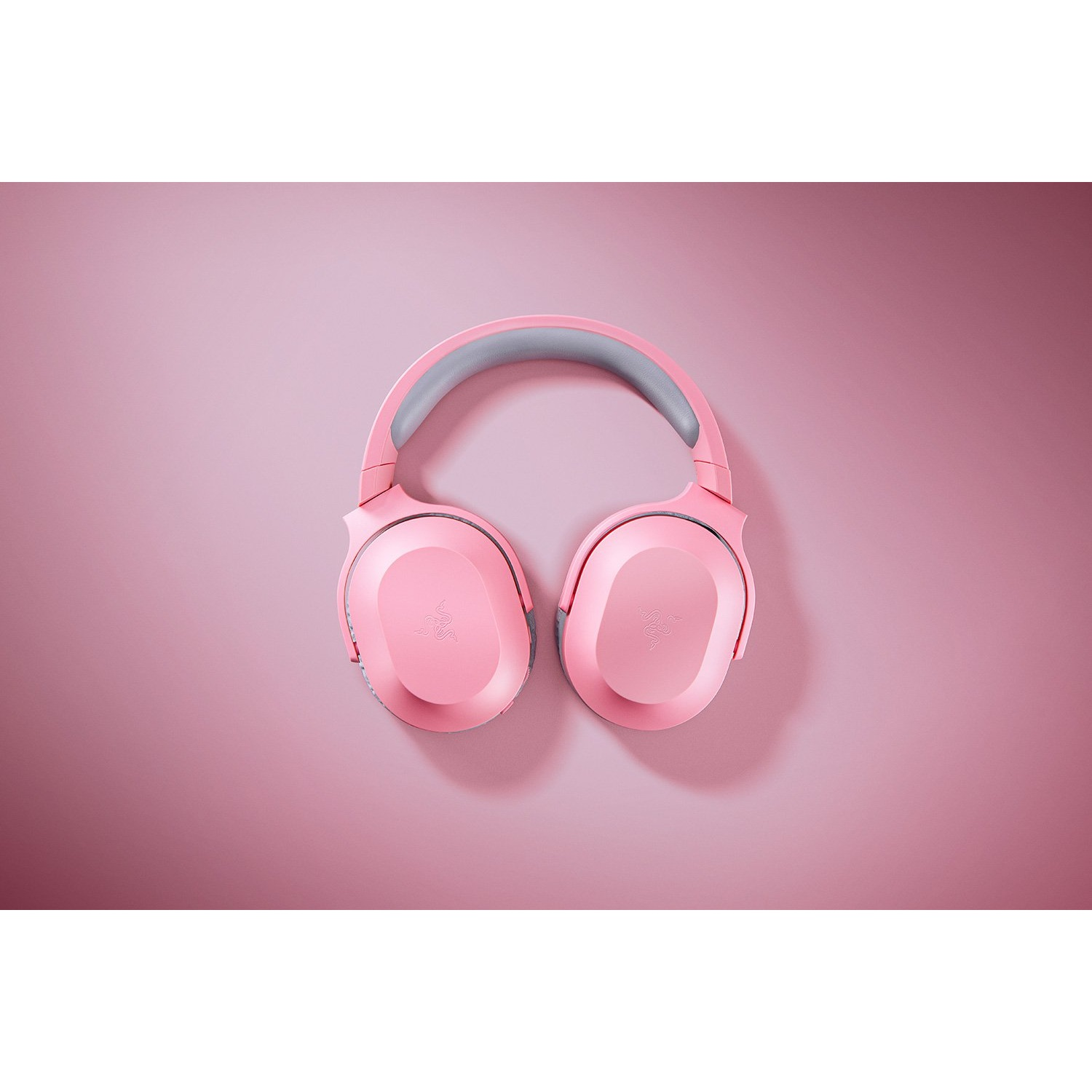 Auriculares rosas sobre un fondo rosa.