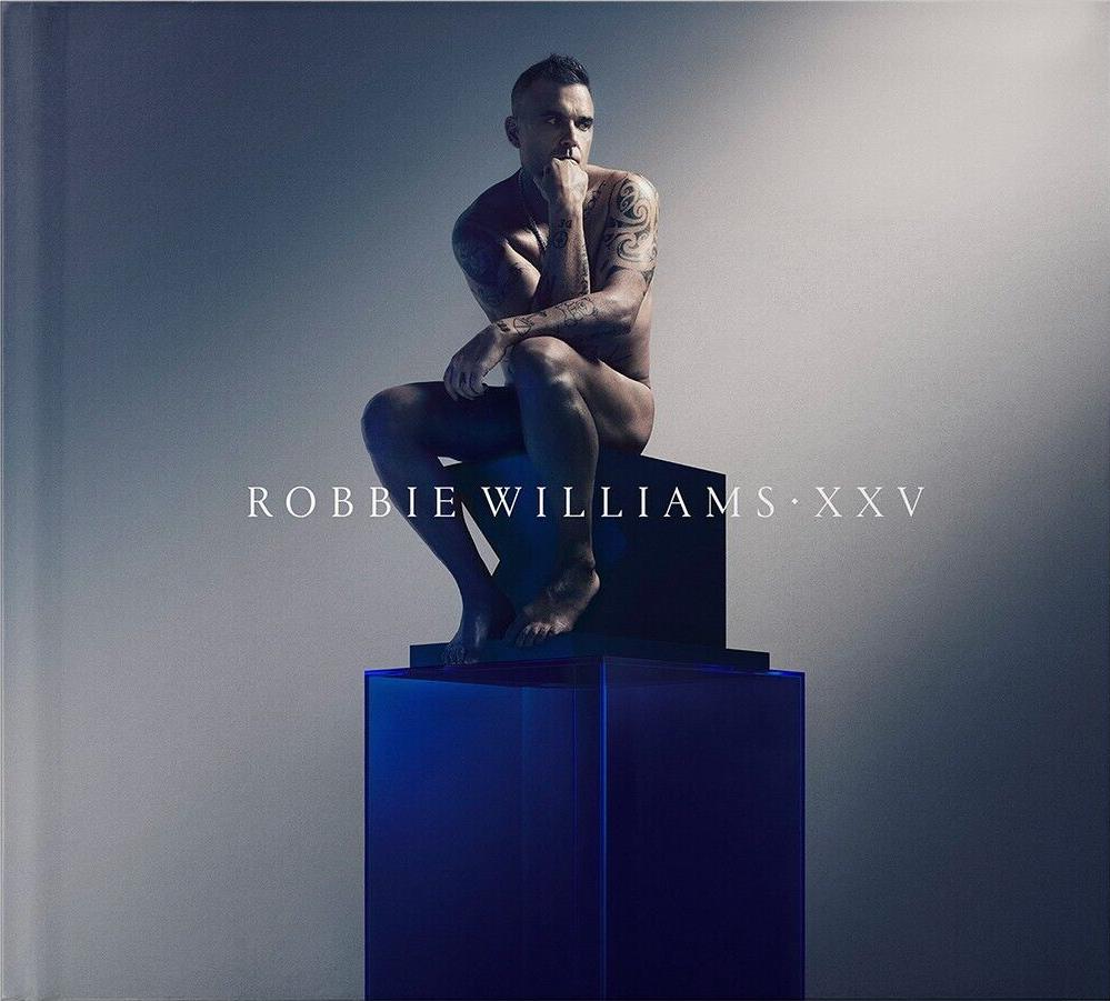Robbie Williams, nu, assis sur un cube bleu. Texte : ROBBIE WILLIAMS • XXV.