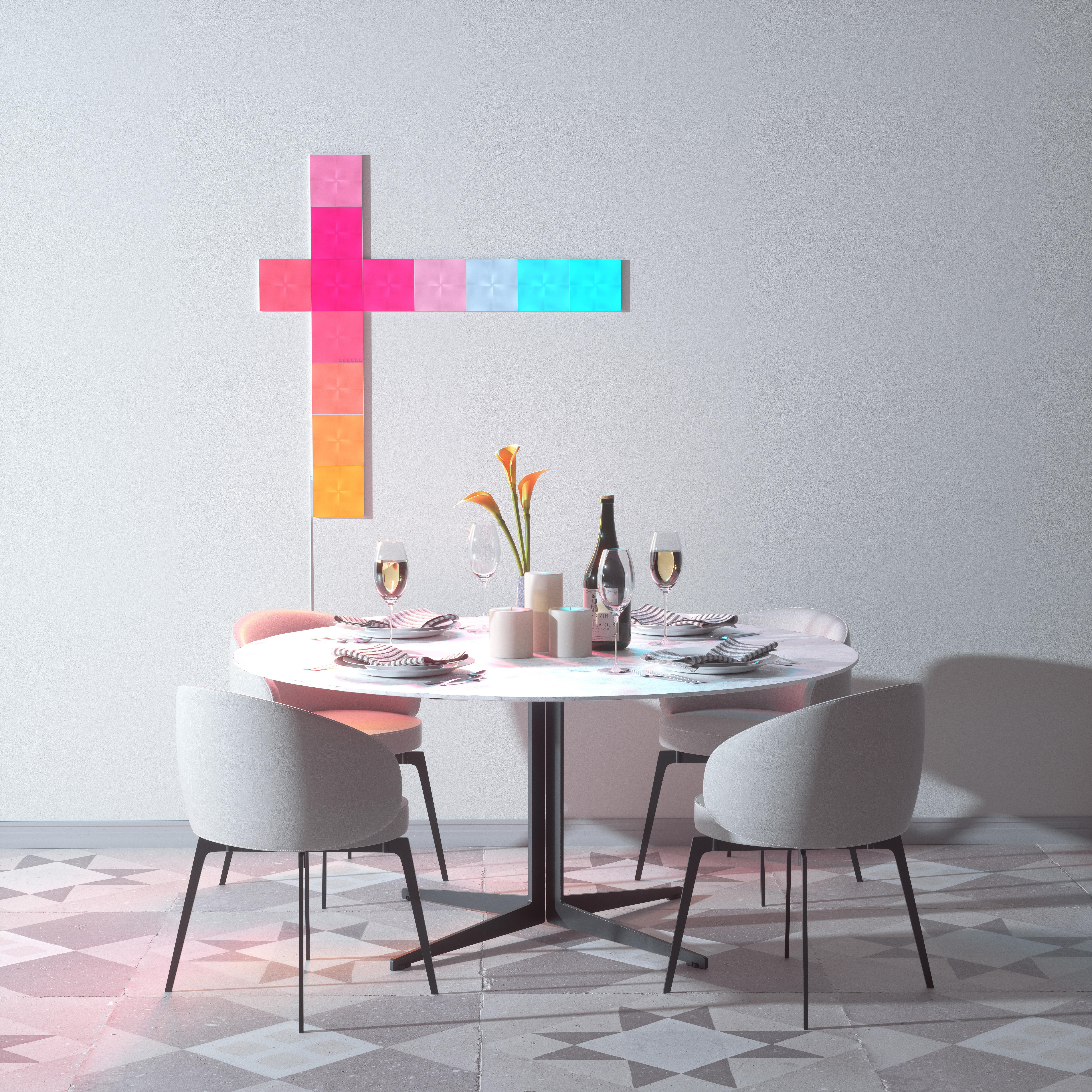 Esszimmer mit rundem Tisch, Stühlen, Blumen und Wandleuchte.