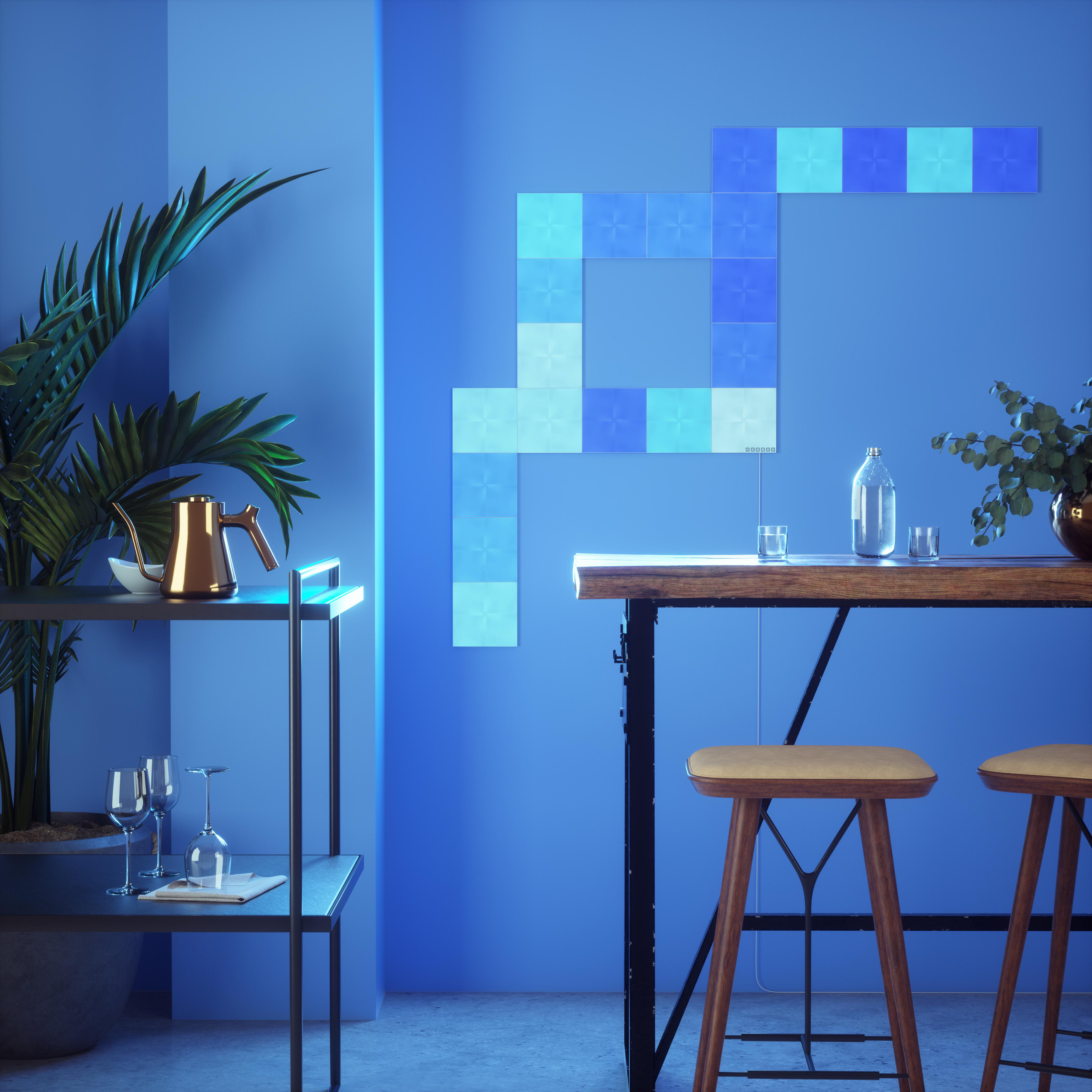 Blaue Wand mit LED-Lichtpaneelen. Holztisch mit Hockern und Dekoration.