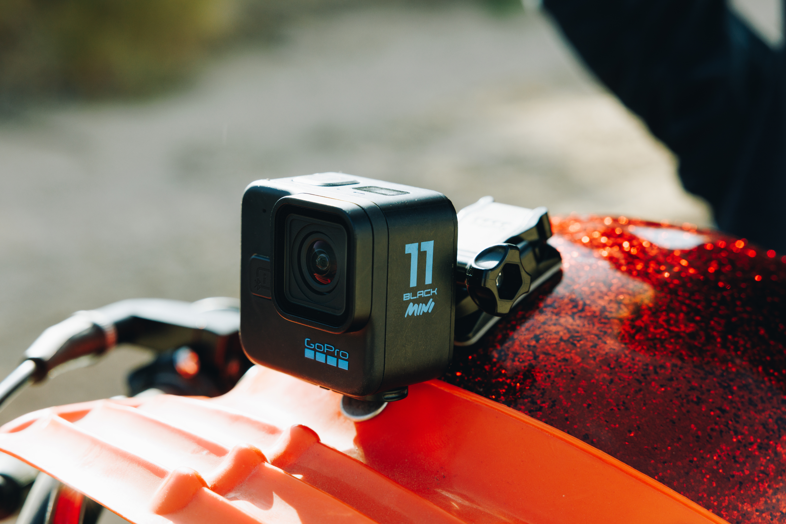 Schwarze GoPro-Kamera auf rotem Helm. Die Kamera hat ein Objektiv und die Zahl 11.