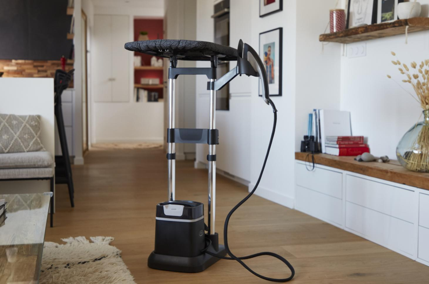 Ironing station in a room. White walls, wooden floor.