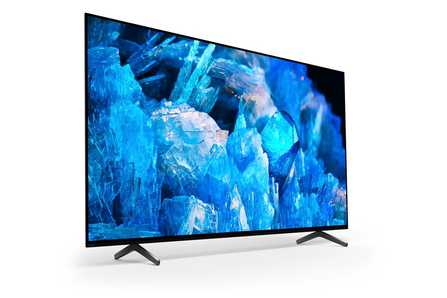 Televisor negro grande con un fondo azul cristalino. Está sobre un soporte negro.