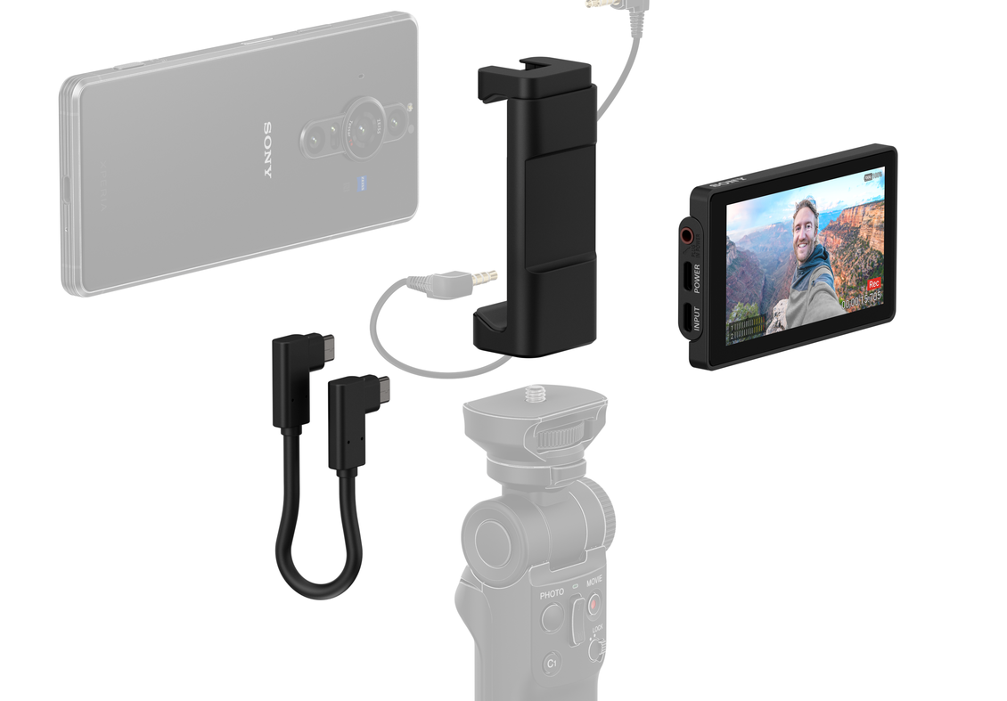 Ein Telefon und Zubehör sind ausgelegt. Es gibt ein Telefon, einen Monitor, Kabel und ein Stativ.