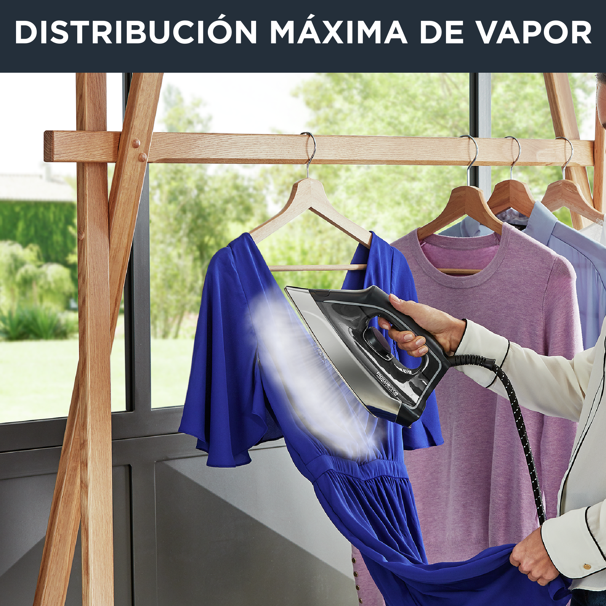 Persona planchando vestido azul con plancha Rowenta, vapor visible.