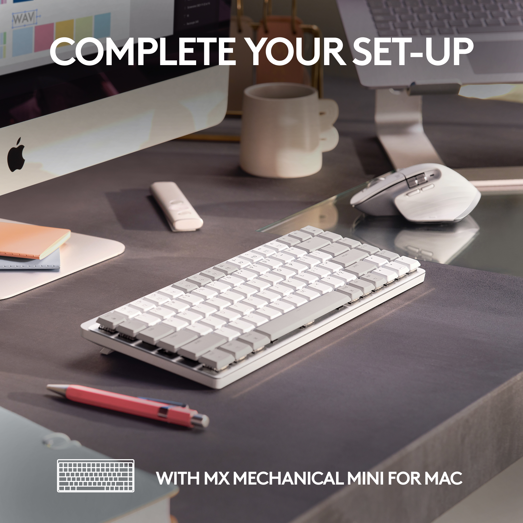 Eine weiße Tastatur, ein roter Stift, ein Computer und eine weiße Maus auf einem grauen Schreibtisch.