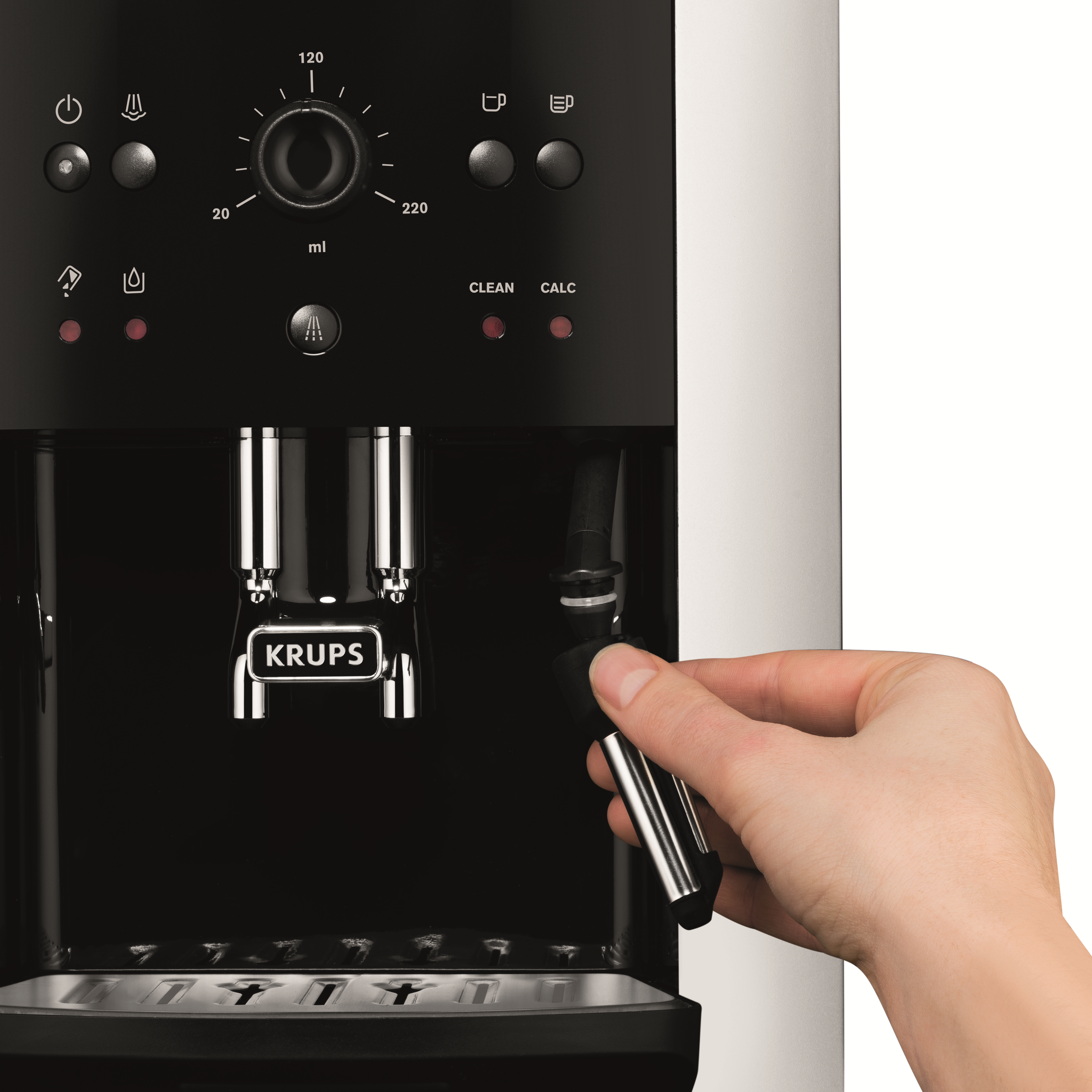 Cafetera con una mano sujetando una pieza metálica. Negro y plateado.