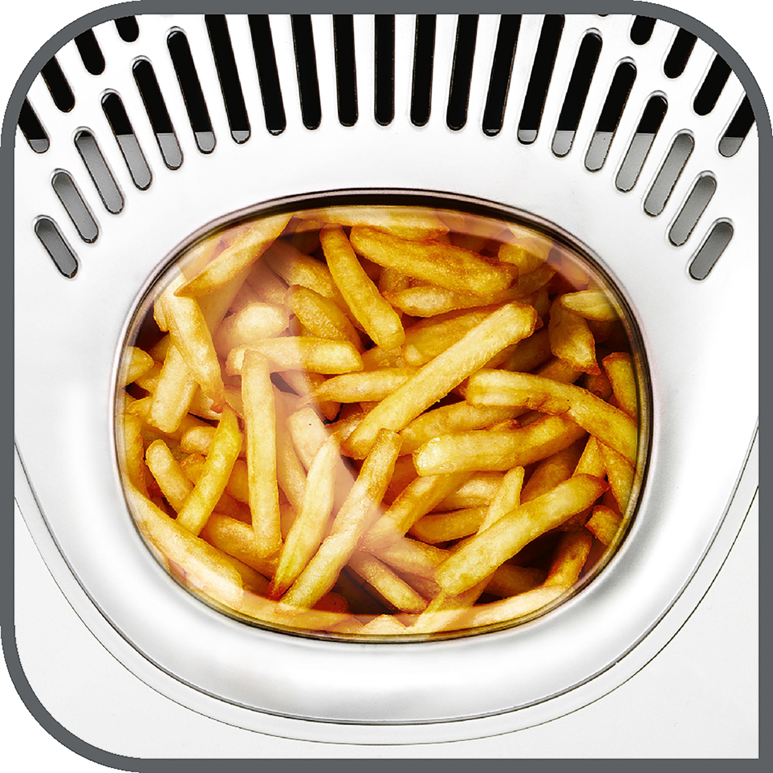 Nahaufnahme von Pommes Frites in einer Heißluftfritteuse. Die Heißluftfritteuse ist weiß.