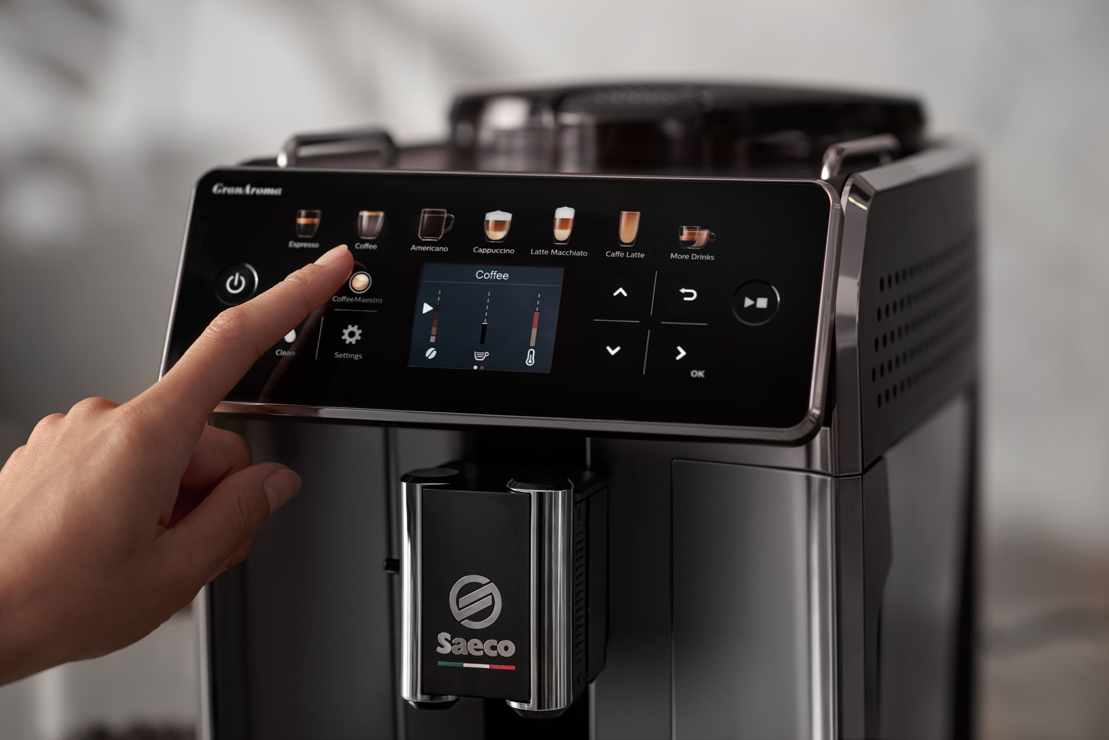 De hand van een persoon die het touchscreen-scherm van een koffiemachine aanraakt.
