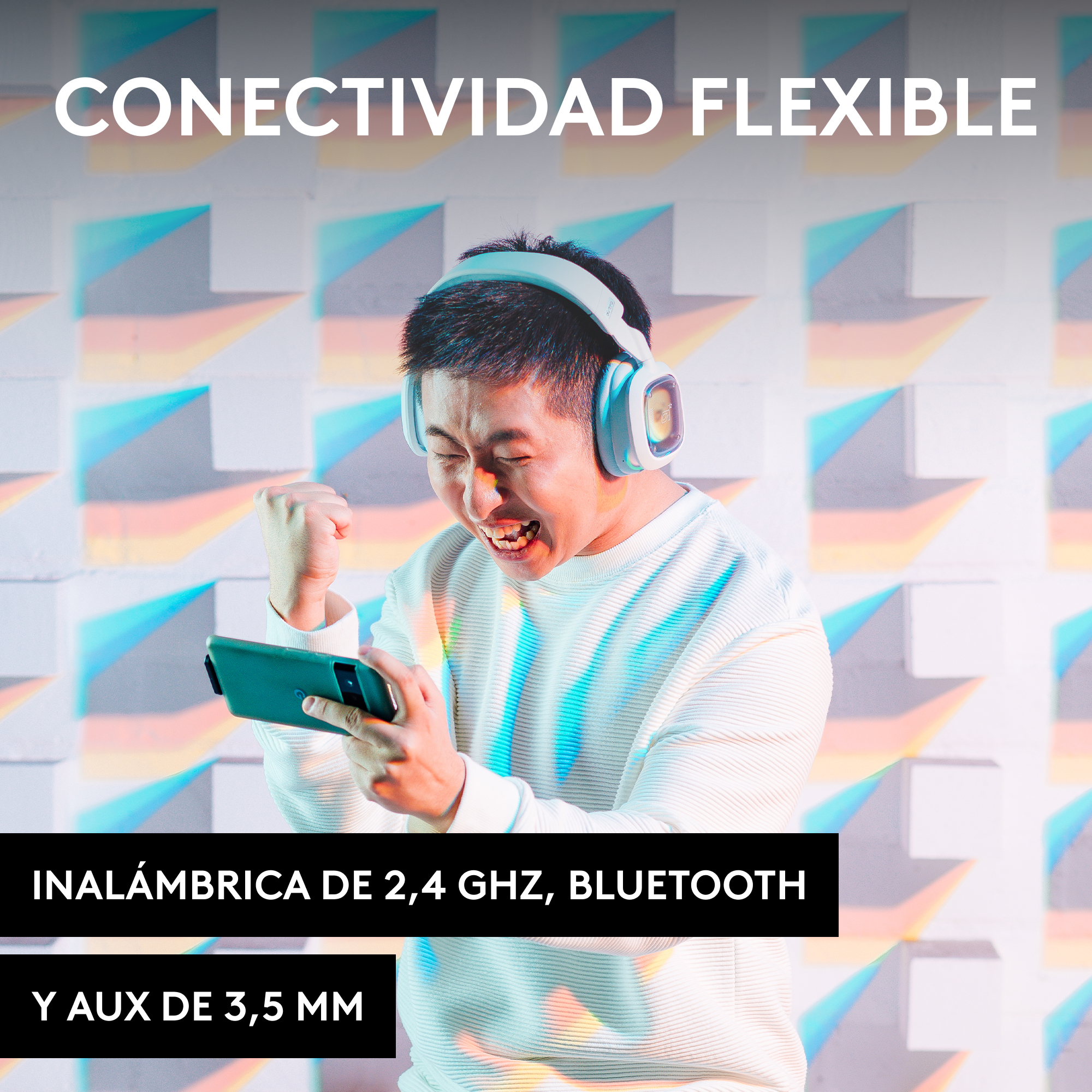Un hombre con auriculares celebra mientras mira un teléfono.