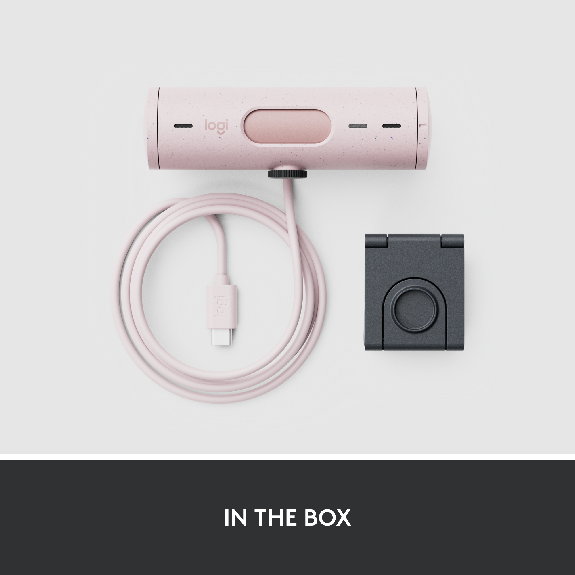 Un appareil rose et blanc avec un câble connecté et un support noir, étiqueté 'IN THE BOX'.