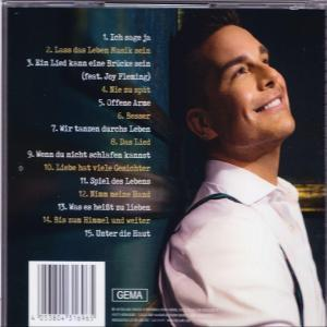 Die Rückseite einer CD-Hülle mit Songtiteln und einem lächelnden Mann.