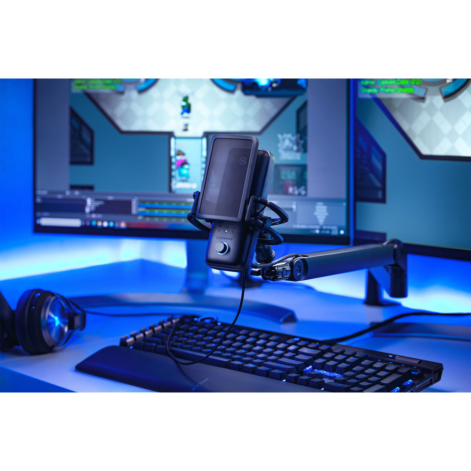 Configurazione di gioco con microfono, tastiera e monitor. Luce blu, scrivania e gioco di sfondo.
