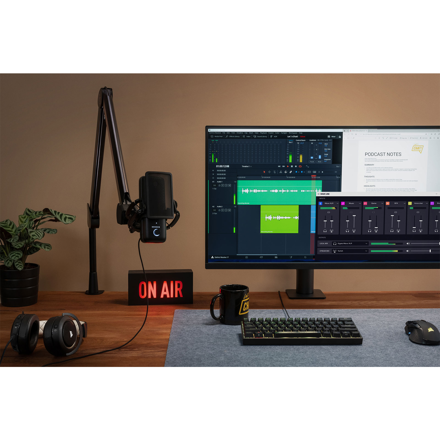 Configurazione podcasting con microfono, cuffie, monitor e tastiera.
