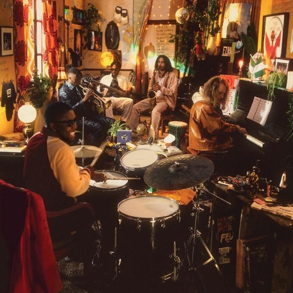 Groupe jouant de la musique dans une pièce avec de nombreux objets.