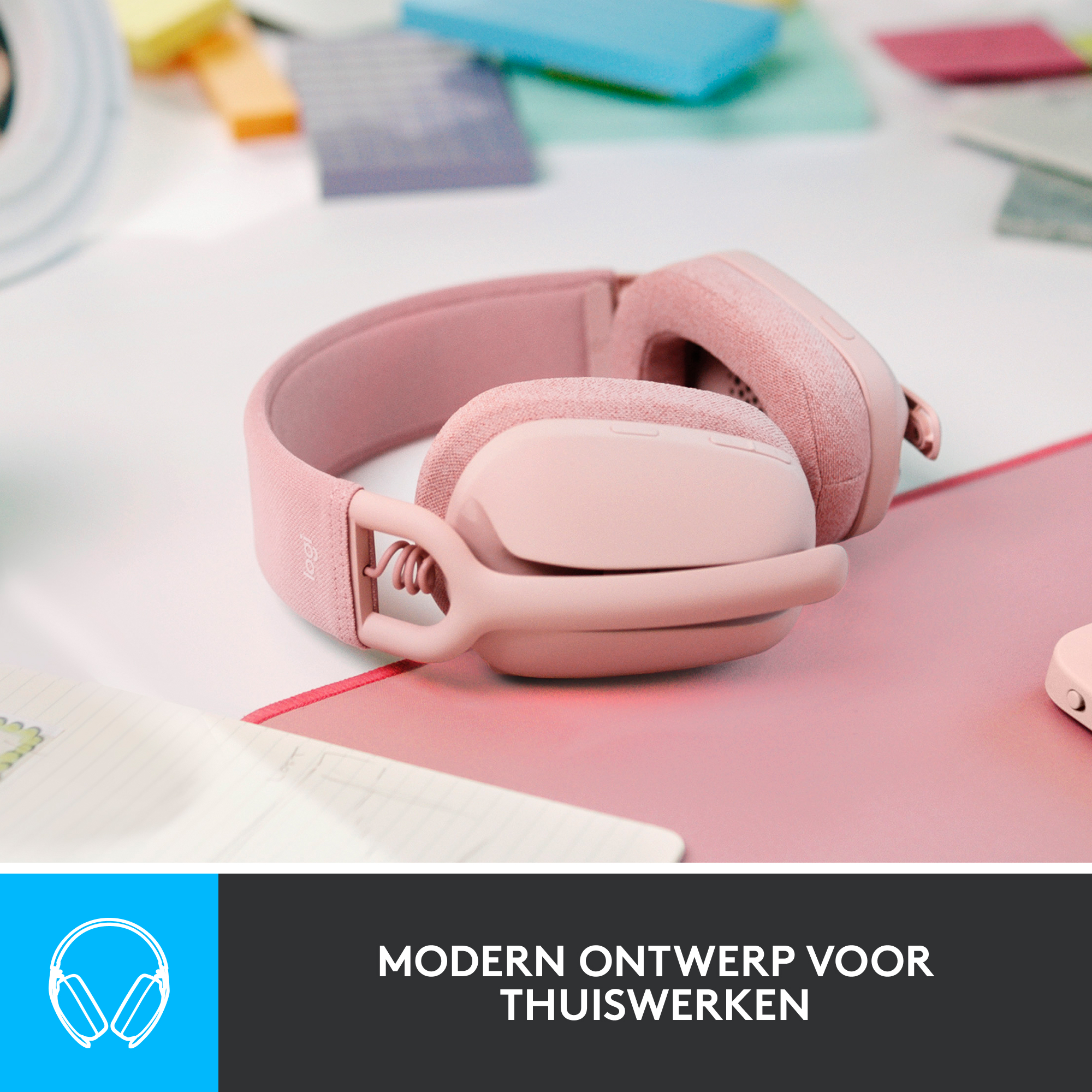 Roze koptelefoon op een roze oppervlak met een wit notitieboek en een blauwe logobox.