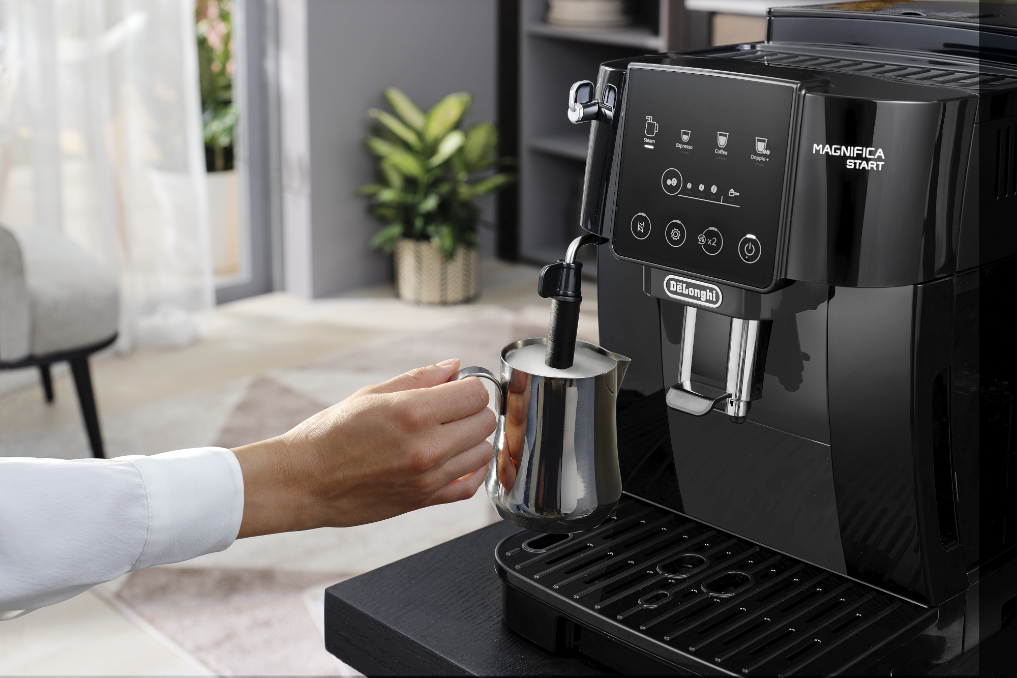 Une personne utilise une machine à café avec une carafe à mousseur de lait.