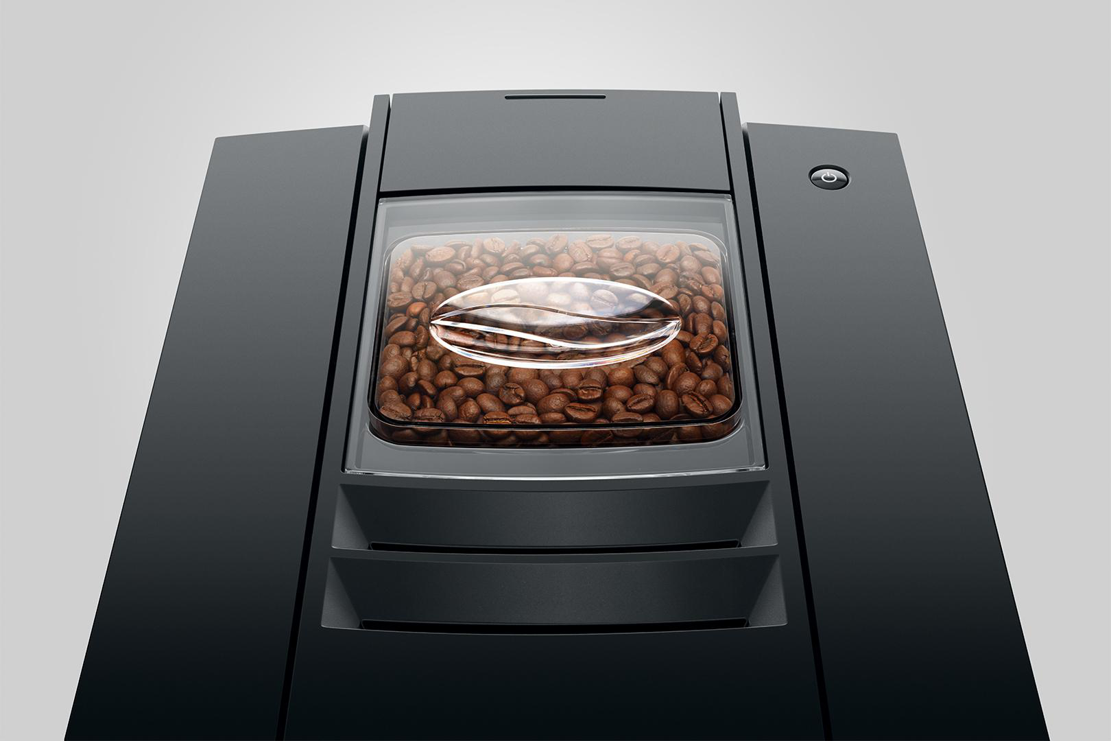 Eine Kaffeemaschine mit einem transparenten Behälter, gefüllt mit Kaffeebohnen.