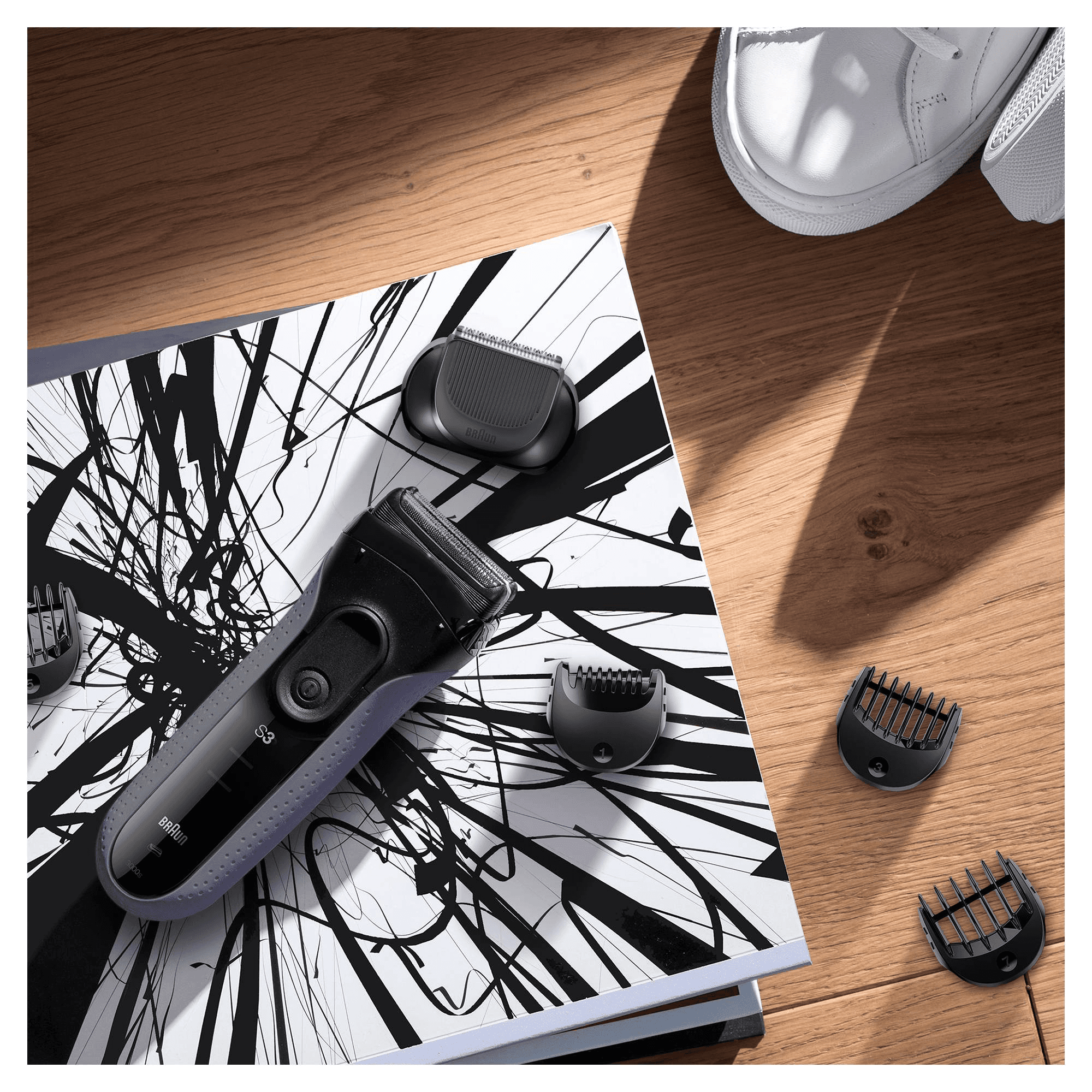 An electric shaver with multiple attachments on a black and white patterned surface.