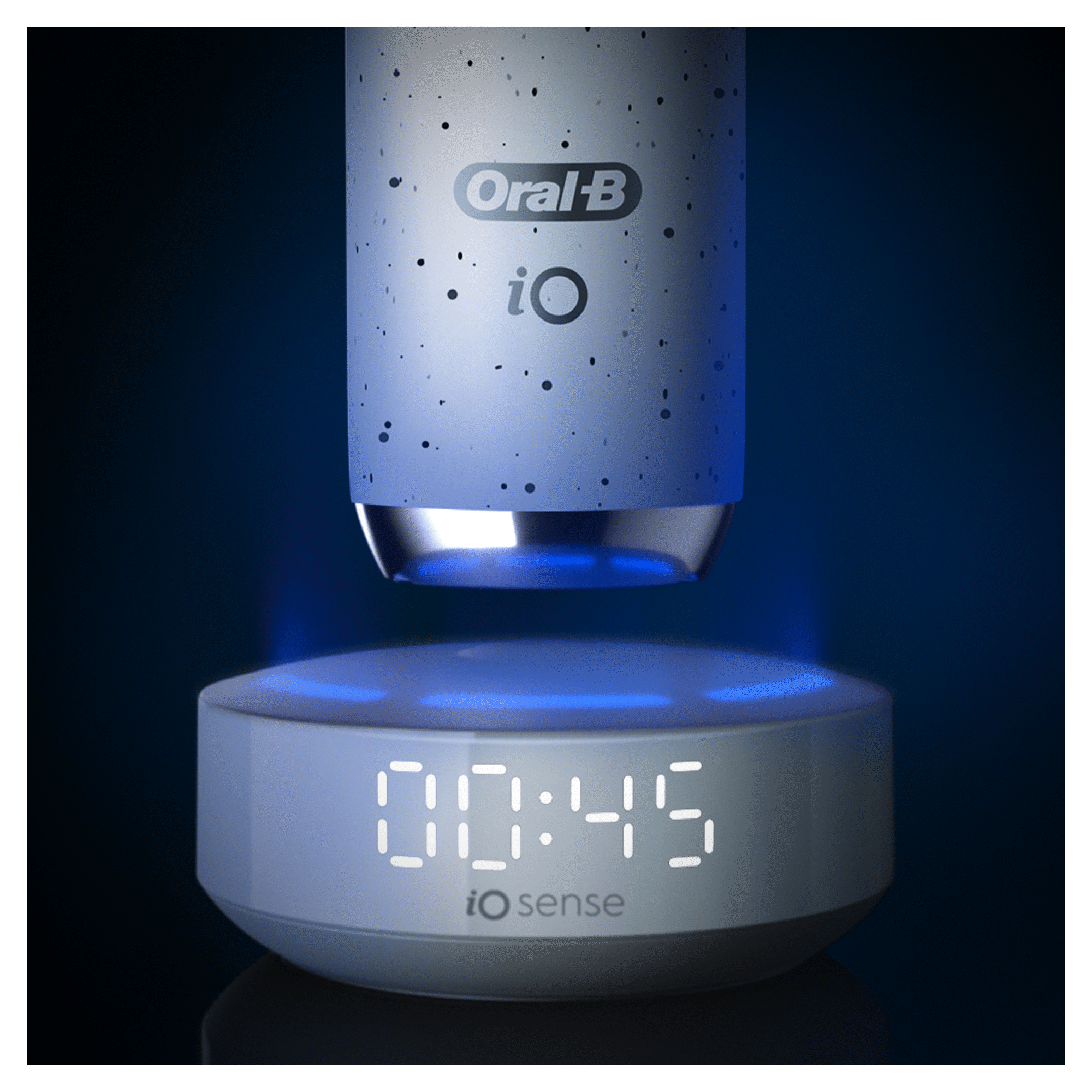 Oral-B iO Series electric toothbrush on charging base. Display shows 00:45 timer. Blue light.