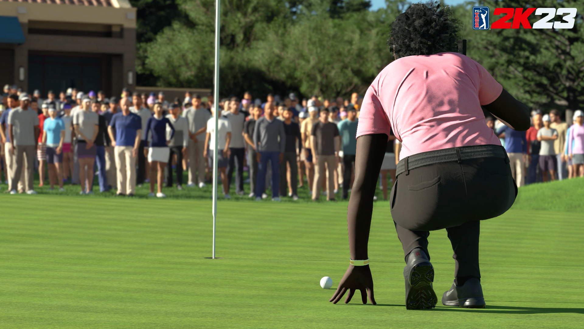 Golfeur sur un parcours de golf alignant un putt, avec une foule de personnes en arrière-plan.