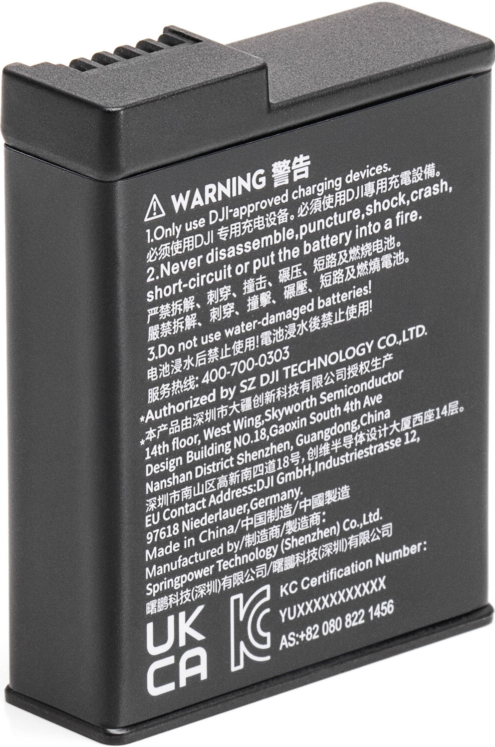 Ein schwarzer Akku mit Text in mehreren Sprachen. Es gibt Warnungen auf Englisch und Chinesisch.