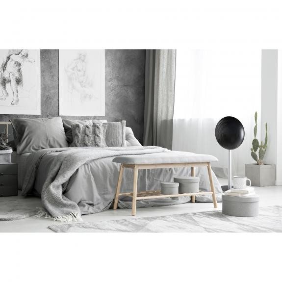 Bedroom scene with a bed, bench, and a speaker. Gray and white colors.